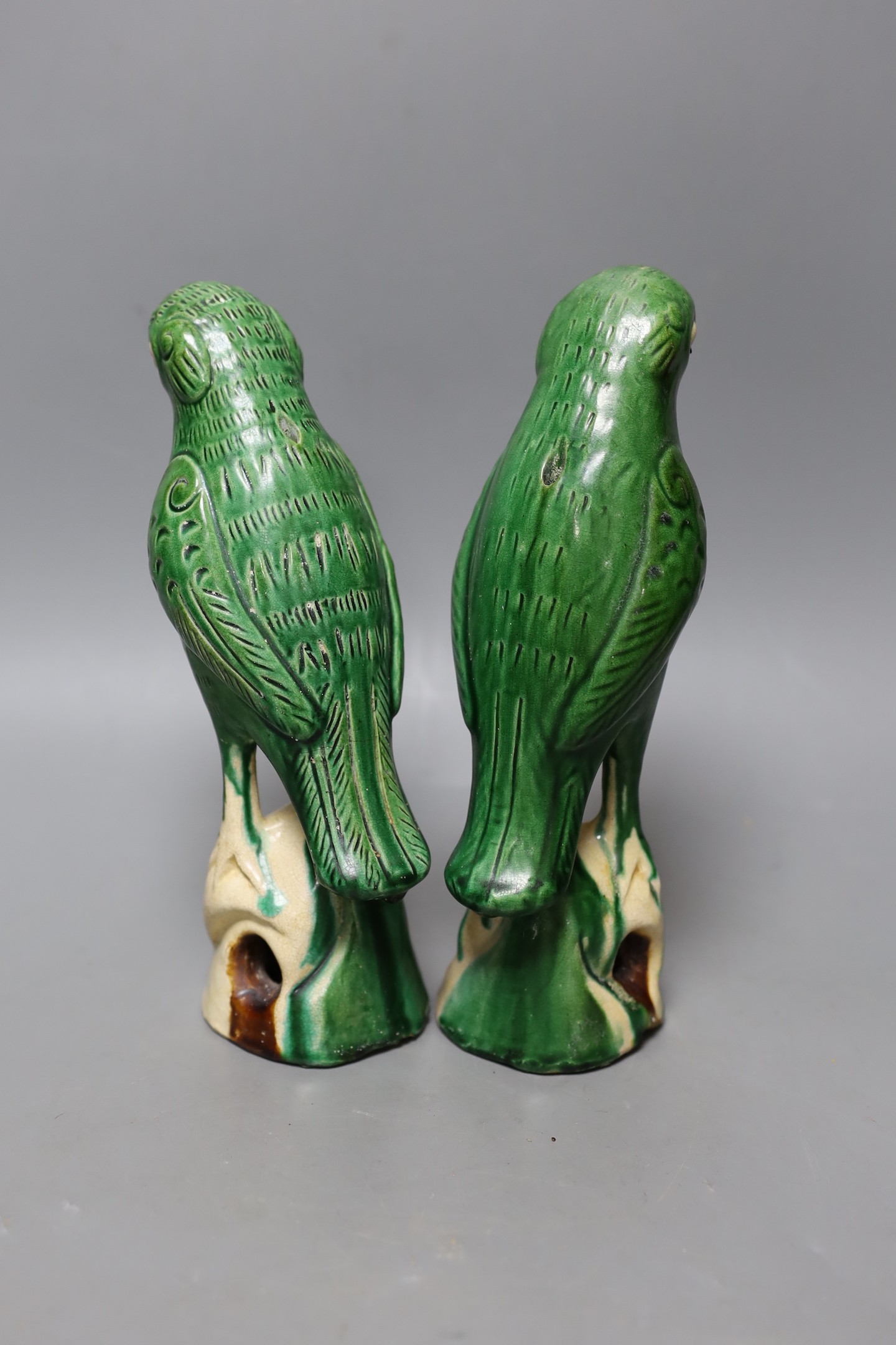 A pair of 19th/20th century Chinese sancai stoneware parrots, 22cm